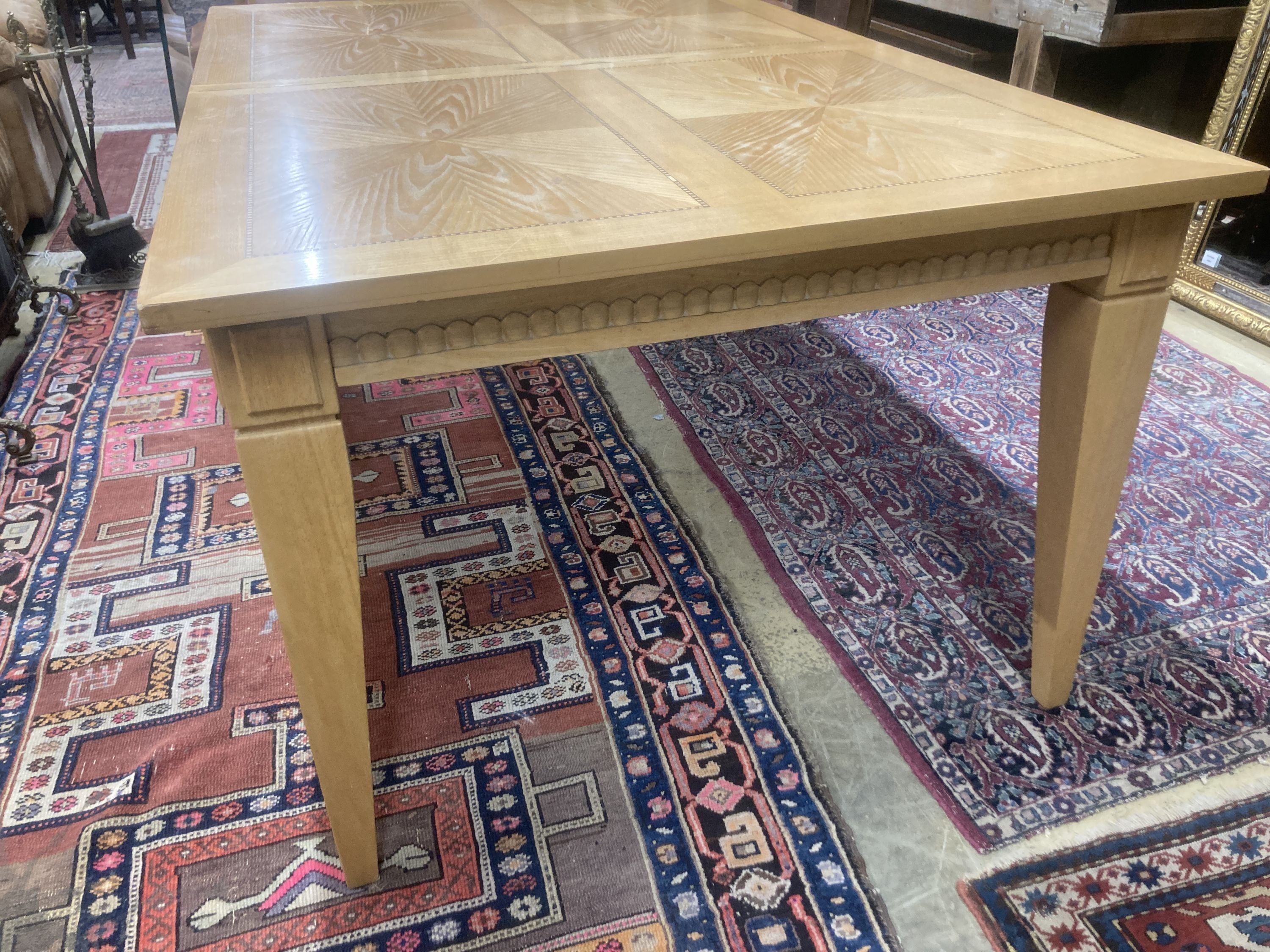 A contemporary inlaid oak extending dining table, 236cm extended, two spare leaves, W.106cm H.75cm